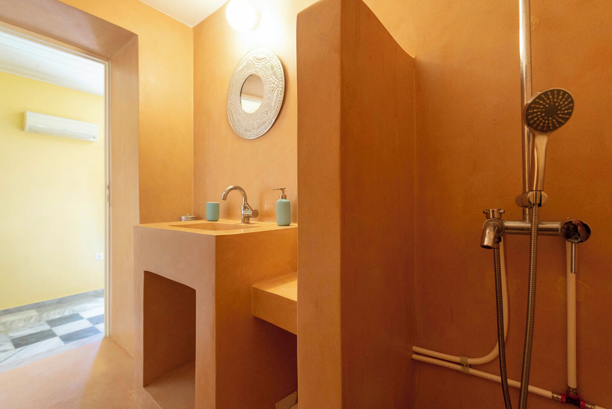 Un bagno con lavandino, specchio e doccia.