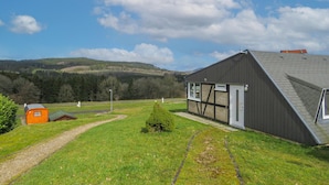 A rural property with a large barn, a small orange outhouse, and a clear path leading to the barn. - Stunning home in Gerolstein with WiFi (Gerolstein)