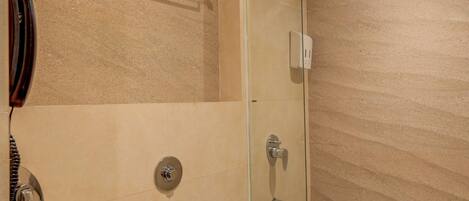 A bathroom with a glass-enclosed shower, a toilet, and a towel rack.