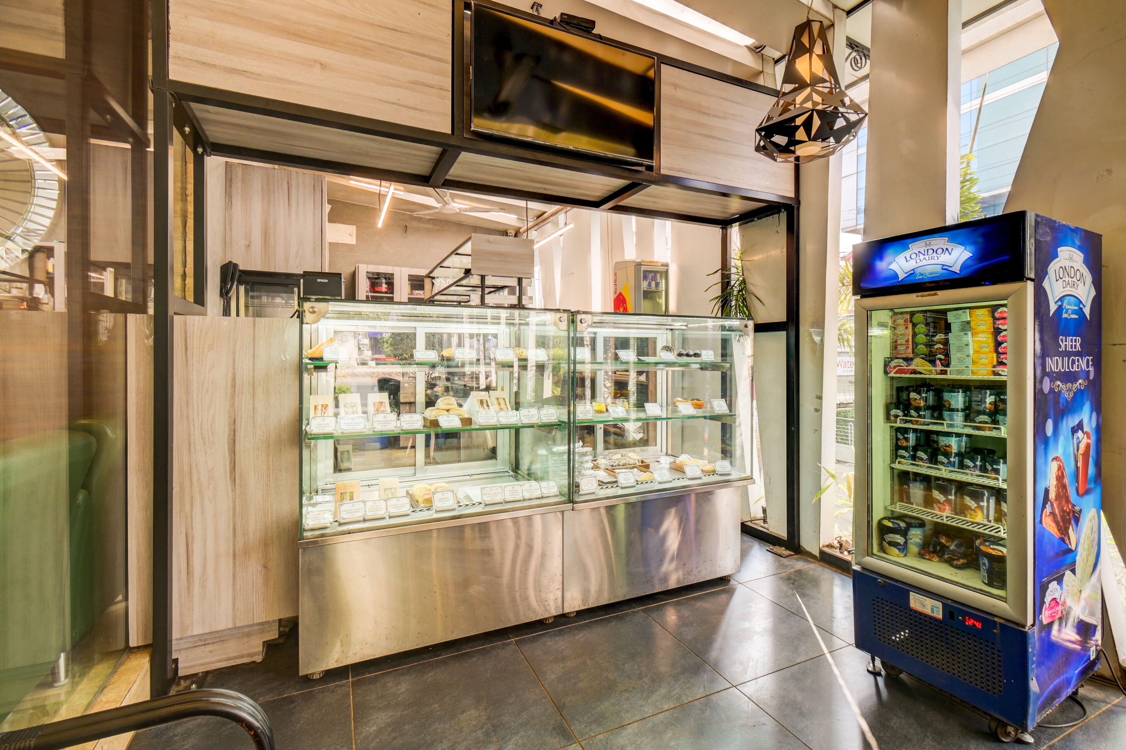 A food display case with various baked goods and a refrigerated display with dairy products.