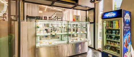 A food display case with various baked goods and a refrigerated display with dairy products.
