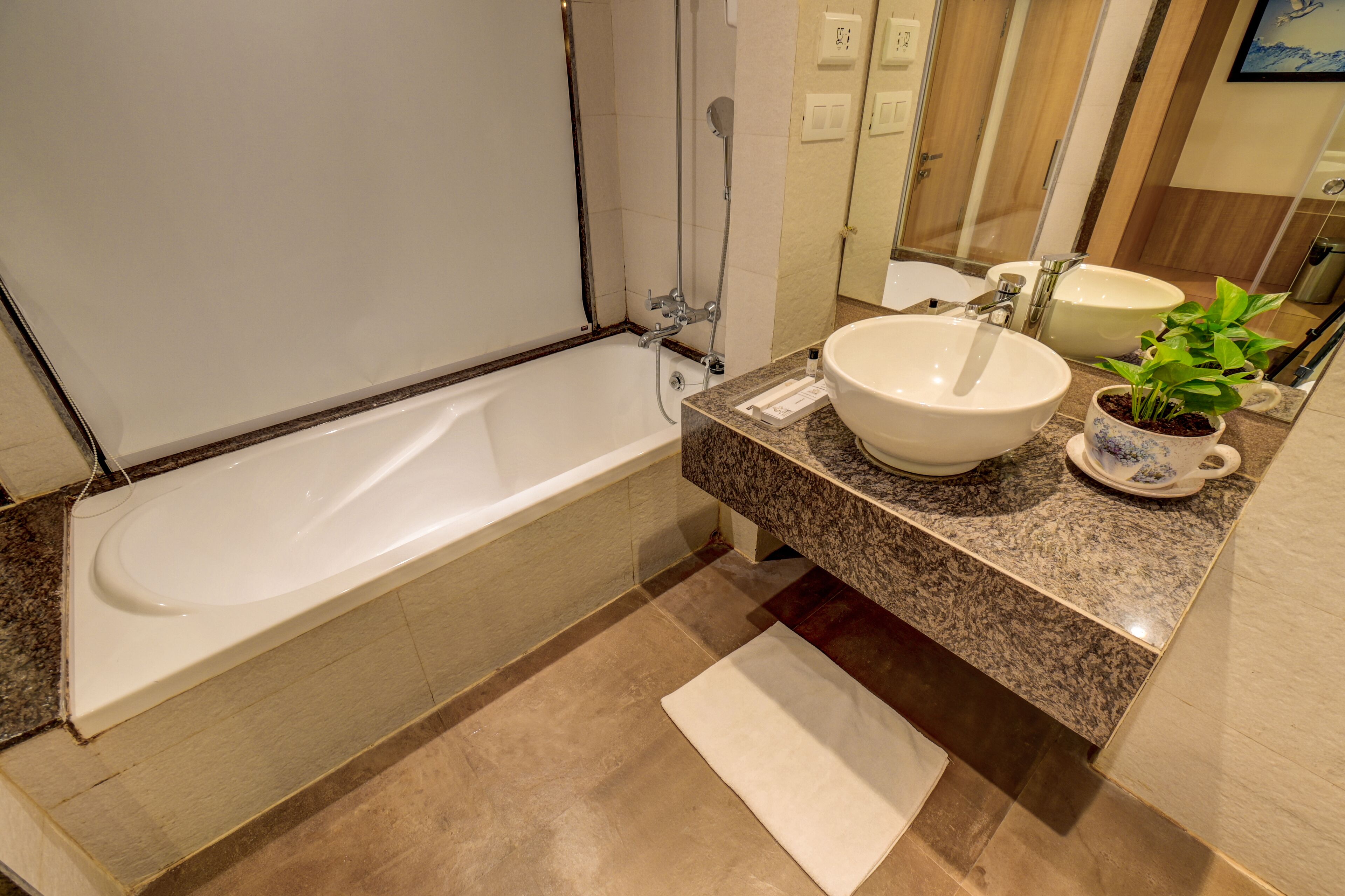 Un baño moderno con bañera, un lavabo espacioso y una planta en maceta.