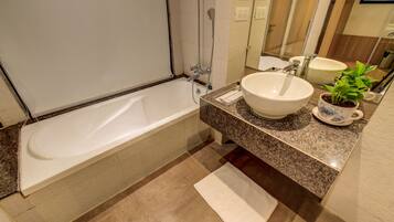Un baño moderno con bañera, un lavabo espacioso y una planta en maceta.