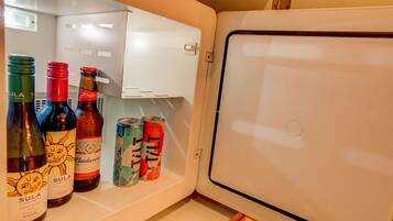 A refrigerator with bottles and cans inside.
