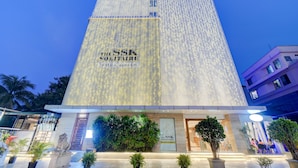 Eine Hotelscheune mit beleuchteten Lichterketten und einem Schild mit der Aufschrift 'The SSK Solitaire Hotel & Banquets'.