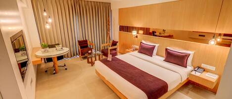 Quarto de hotel moderno com uma cama grande, mesas de cabeceira, uma escrivaninha e uma cadeira.