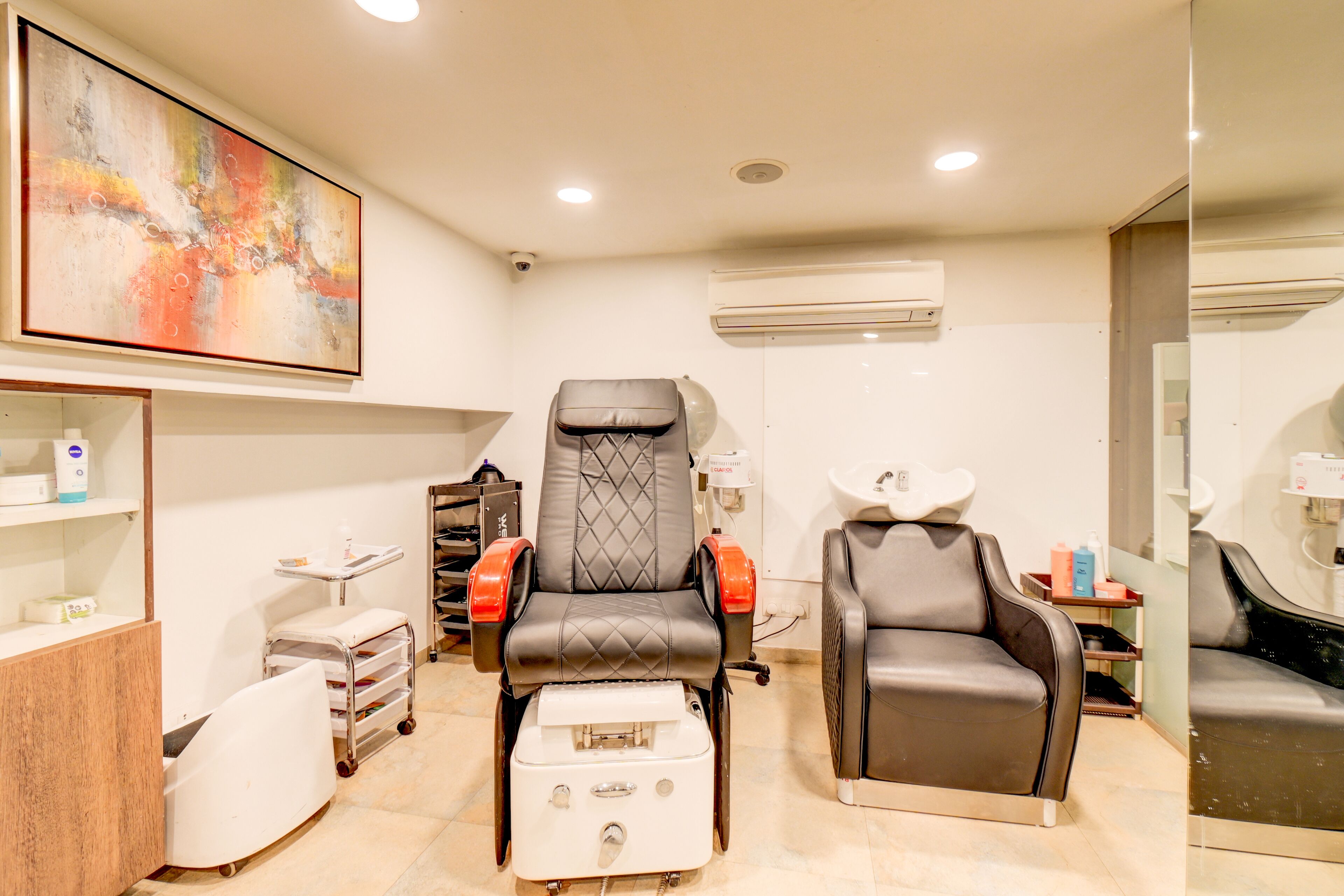 A modern medical facility with a reclining chair, a footrest, and a sink.