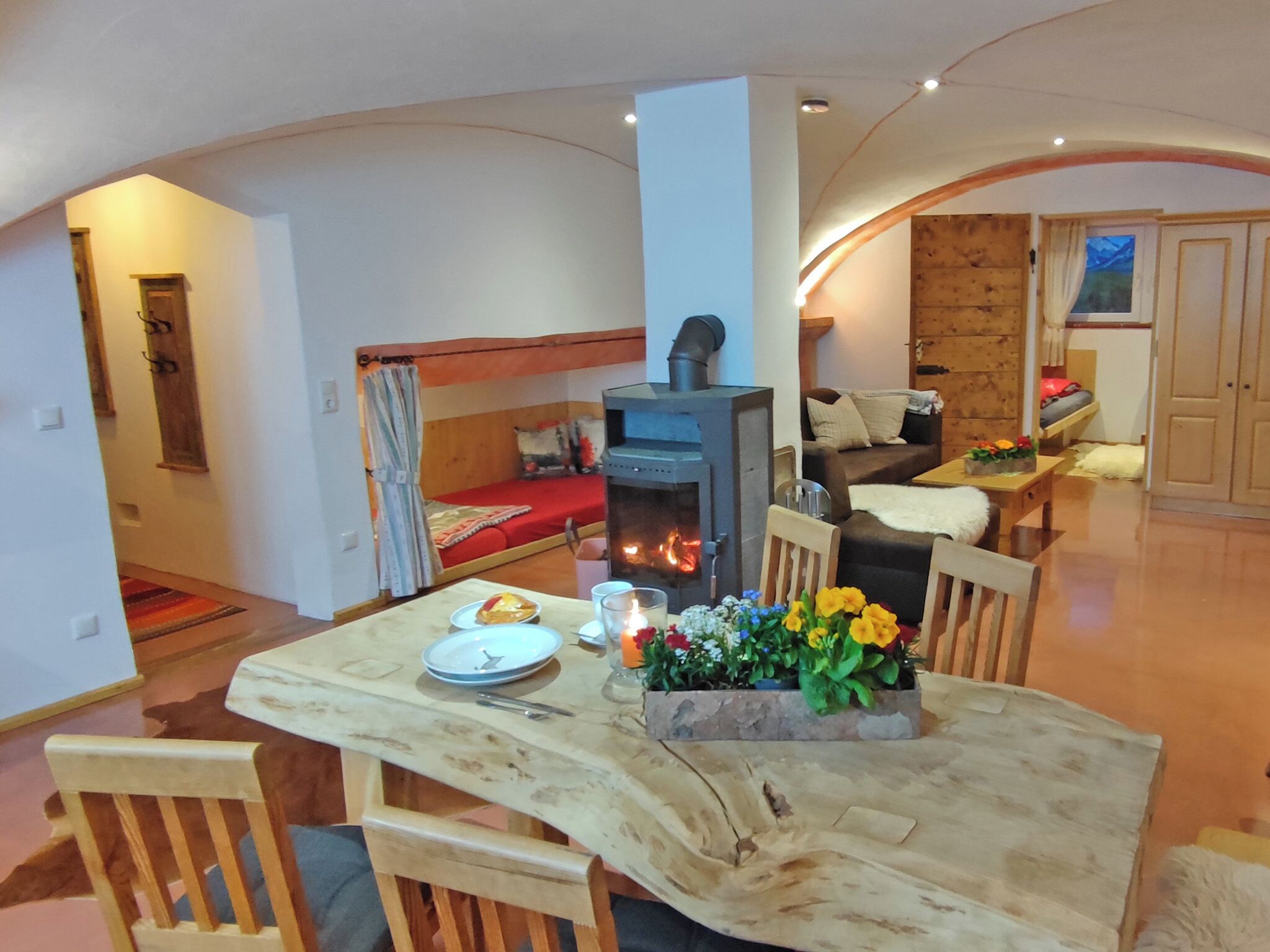 Un salon chaleureux avec une cheminée, une table à manger avec des chaises et un canapé.
