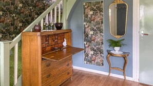 Une commode en bois avec des tiroirs, un miroir et une petite table sur laquelle est posée une plante.