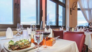 A restaurant table set with wine glasses, a bottle of red wine, and a dish of food. - Lovely home in Gerolstein with WiFi (Gerolstein)