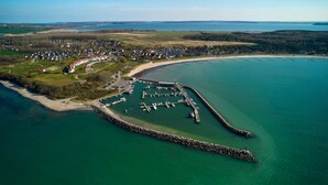An aerial view of a coastal town with a marina, houses, and a beach. - Bernstein Suite—right on the beach! - Bernstein Suite (Glowe)
