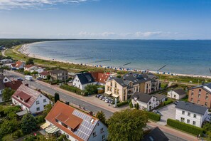 A coastal town with a beach, houses, and a road.