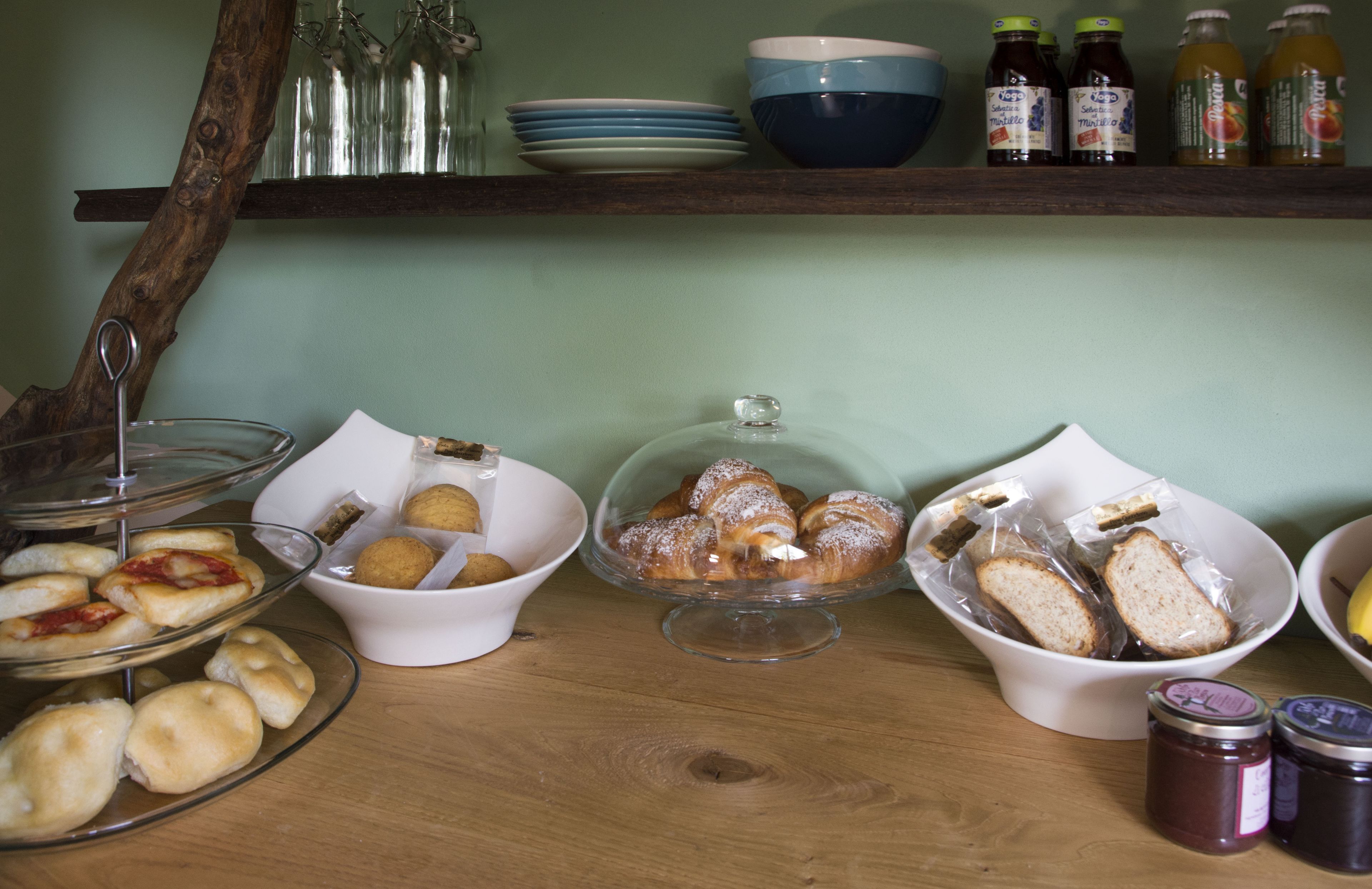 A breakfast buffet with pastries, bread, and condiments.