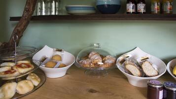 A breakfast buffet with pastries, bread, and condiments.