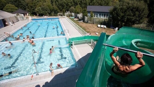 Un espace piscine comprenant plusieurs bassins et un toboggan aquatique.