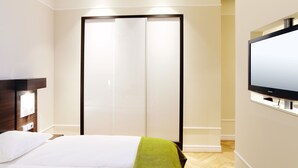 A hotel room with a bed, a television, and a sliding door closet. - Hapimag Resort Dresden (Dresden)