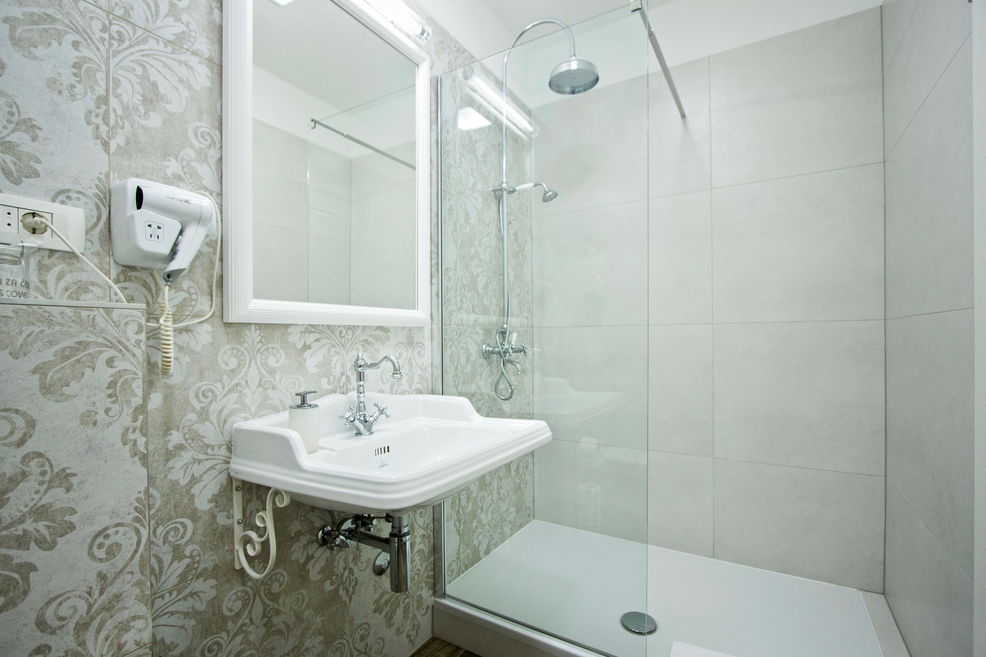 A bathroom with a shower, a sink, and a mirror.
