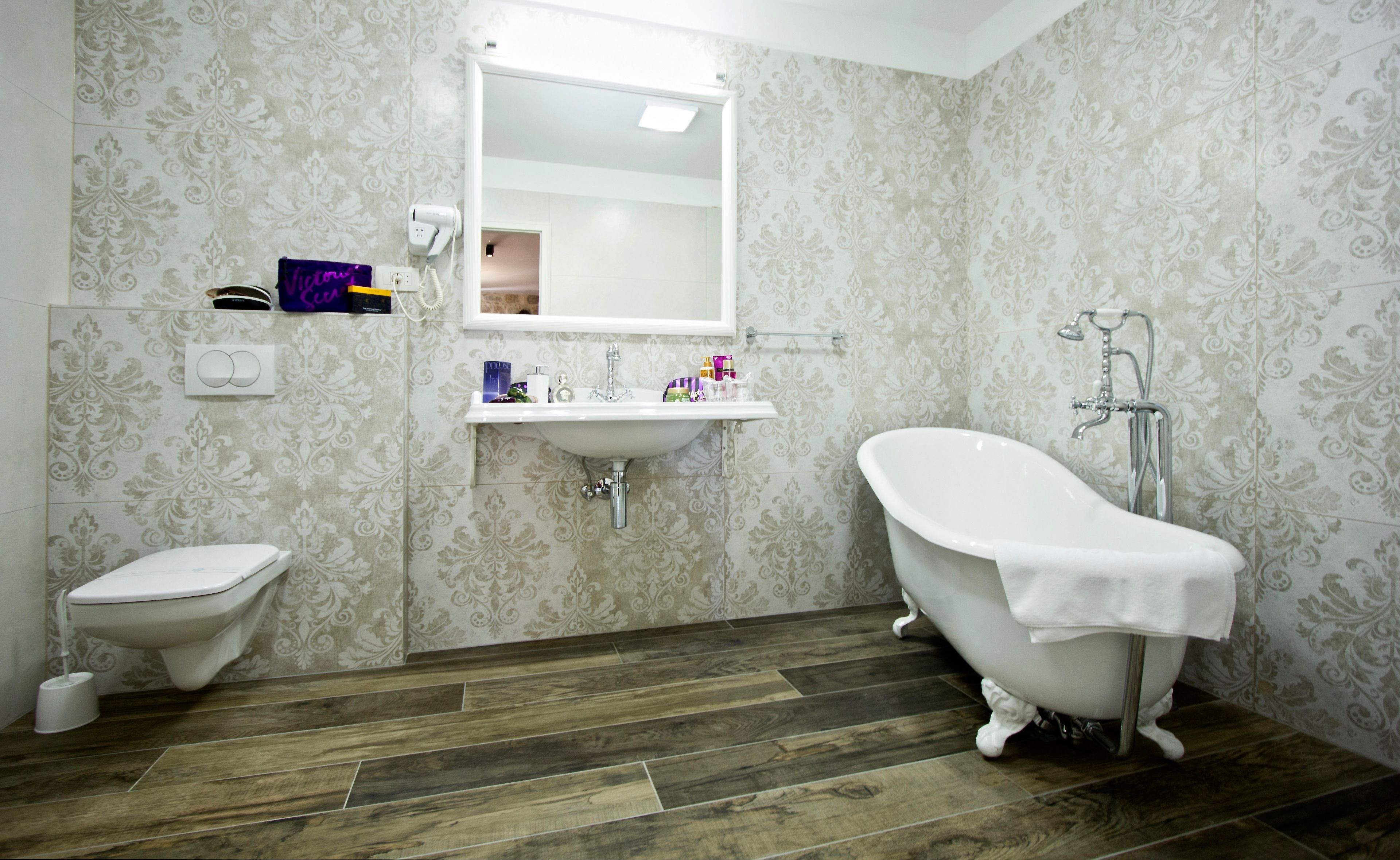 Ein Badezimmer mit Toilette, Waschbecken und freistehender Badewanne.