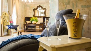 A room with a vintage aesthetic, featuring a chandelier, a mirror, a table with a champagne bottle, and two glasses. - Plaza Marchi Old Town - MAG Quaint & Elegant Boutique Hotels (Split)