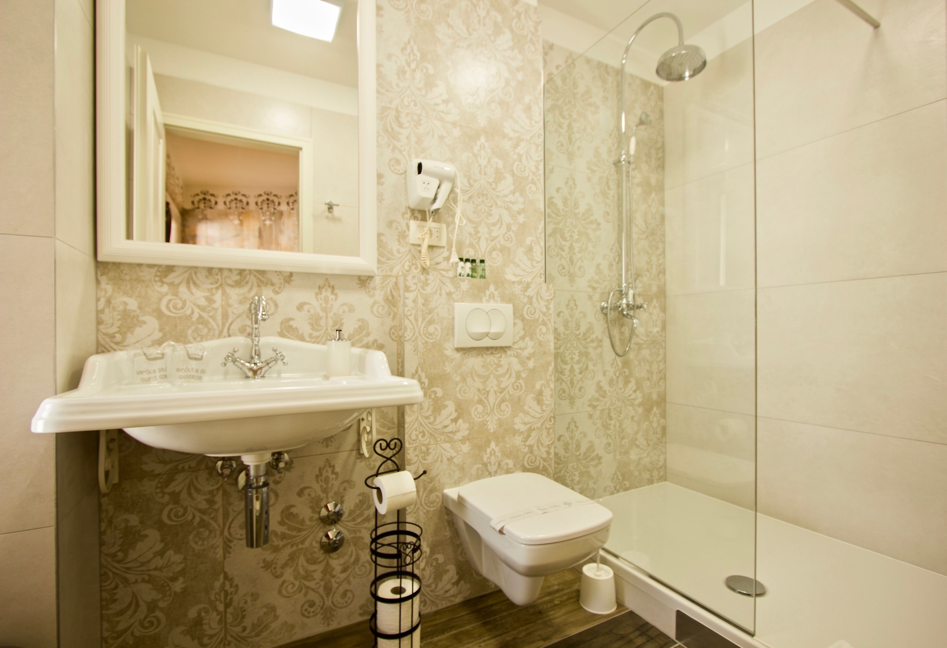 A bathroom with a sink, toilet, and shower.