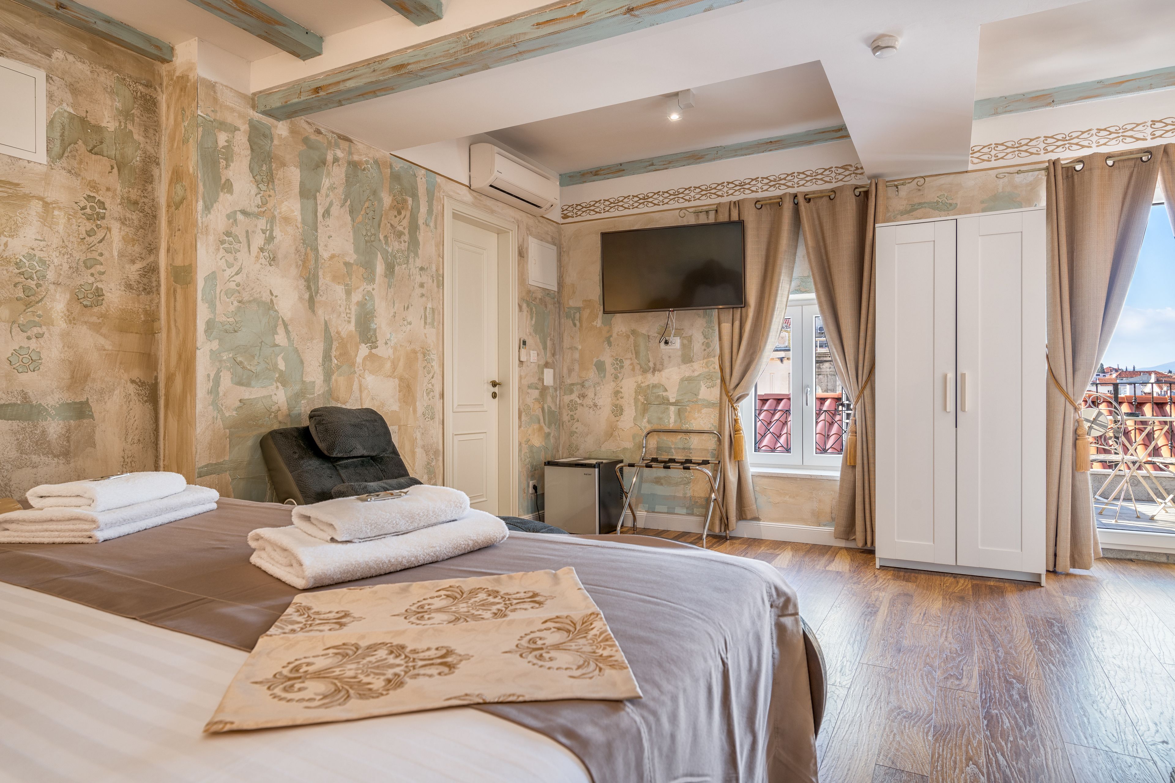 A hotel room with a bed, a massage chair, a small table, and a TV.