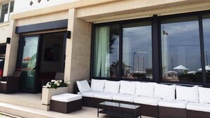 A hotel named "AURORA" with a modern exterior, large windows, and outdoor seating area. - Hotel Aurora (Gabicce Mare)