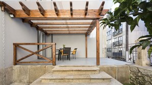 A stone staircase leading to a wooden pergola with a table and chairs underneath. - Apartment Alegria Street by Sweet Porto - Free Parking (Porto)