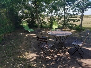 An outdoor seating area with a round table and four chairs. - La Ferme Chauvet (Chantenay-Villedieu)