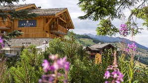 Un edificio in legno con un cartello che riporta 'ANITA' e un muro in pietra con la scritta 'BAR LOUNGE'.