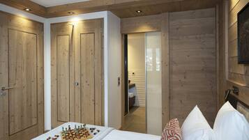 A bedroom with wooden walls, a bed with pillows, and a chessboard on the floor.