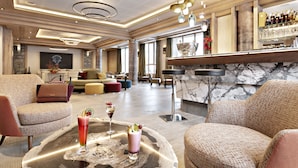 Un'ampia hall con area bar, posti a sedere e un bancone in marmo.