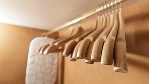 Ένα ξύλινο κρεμαστάρι για παλτό με αρκετές κρεμάστρες.