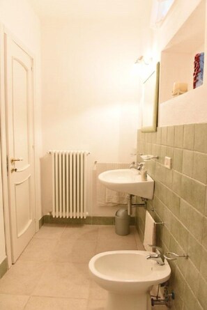 A small bathroom with a white sink, a mirror, and a radiator. - B&B Parco Lamione (Gioia del Colle)