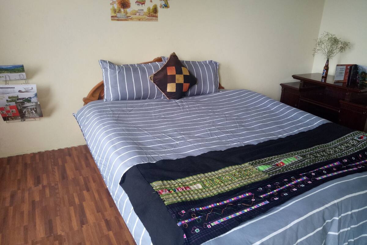 A neatly made bed with striped bedding and a decorative throw blanket.