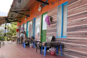 A building with a wooden facade, outdoor seating, and a sign that reads "Juice."