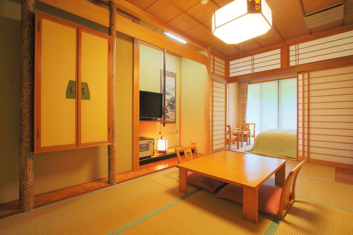 Perinteinen japanilainen huone, jossa on tatamimatto, matala pöytä ja liukuvat ovet.