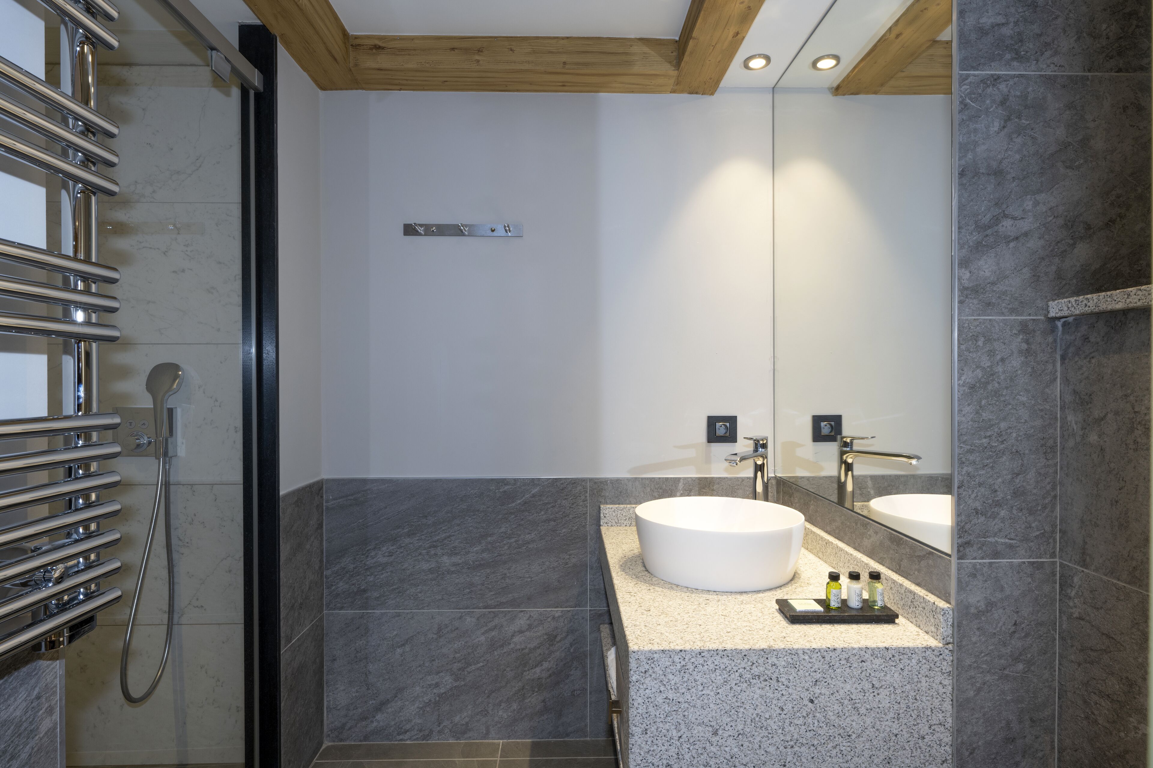 Un baño moderno con cabina de ducha, dos lavamanos y un espejo.