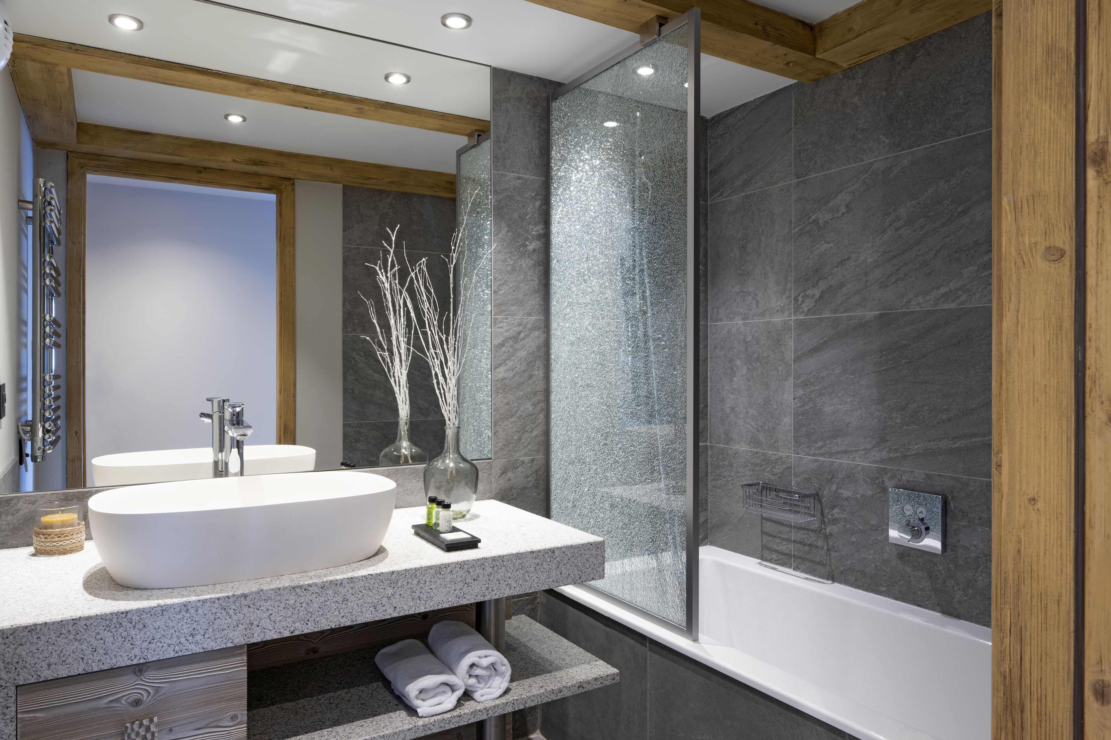 A modern bathroom with a large sink, mirror, and bathtub.