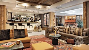 Un moderno hall de hotel con un área de bar, sofás y una mesa de centro.