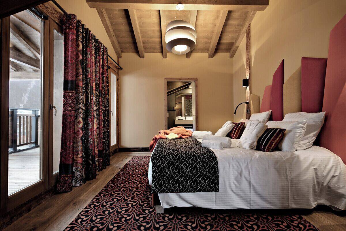Un dormitorio con una cama grande, un tapete estampado y vistas al exterior.