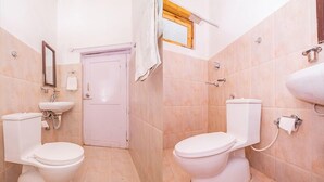 A bathroom with two toilets, a sink, and a mirror. - Shangrila Resort Nubra (Leh)