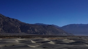A desert landscape with mountains in the background. - Shangrila Resort Nubra (Leh)