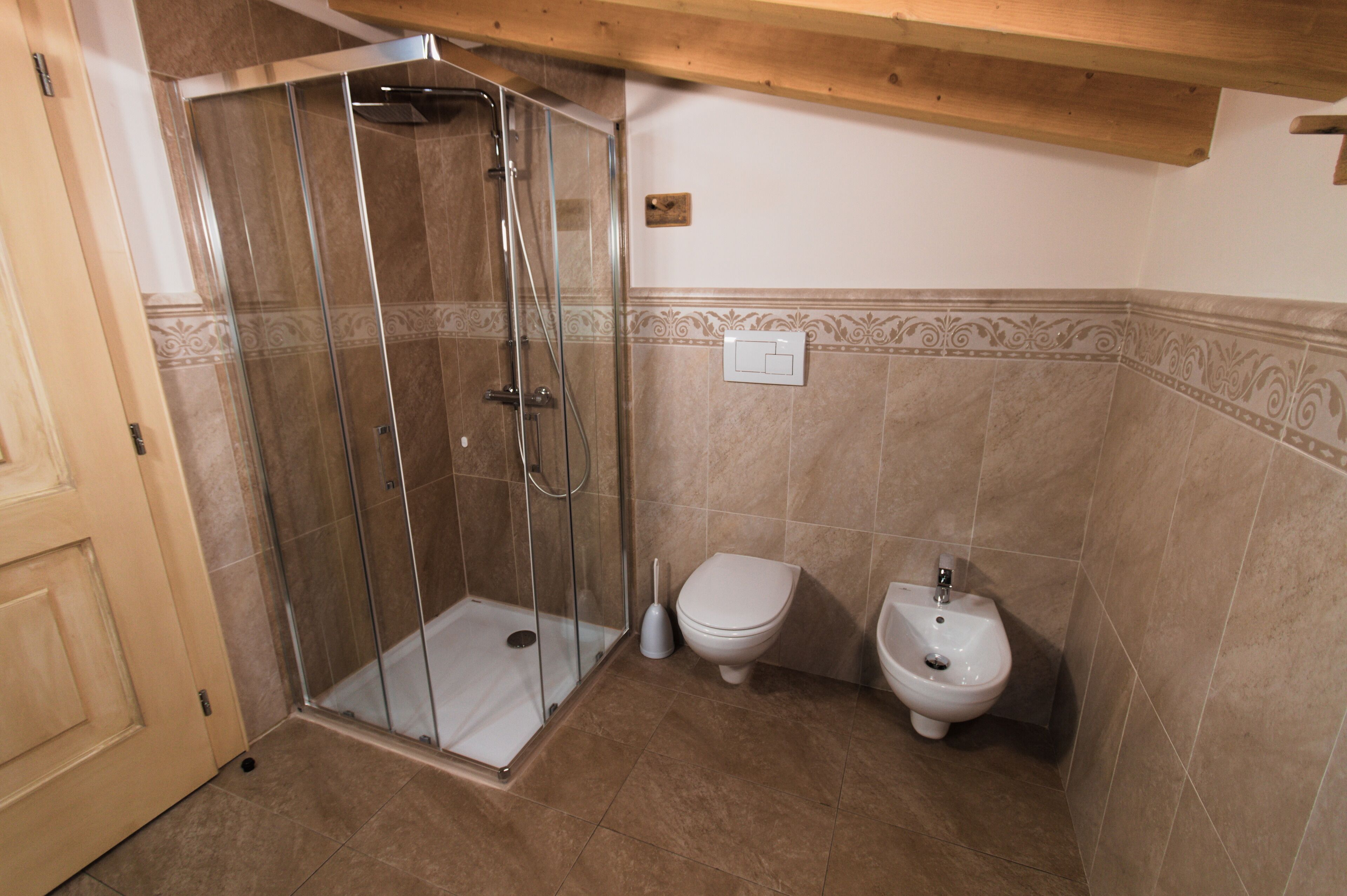 A bathroom with a glass-enclosed shower, a toilet, and a bidet.