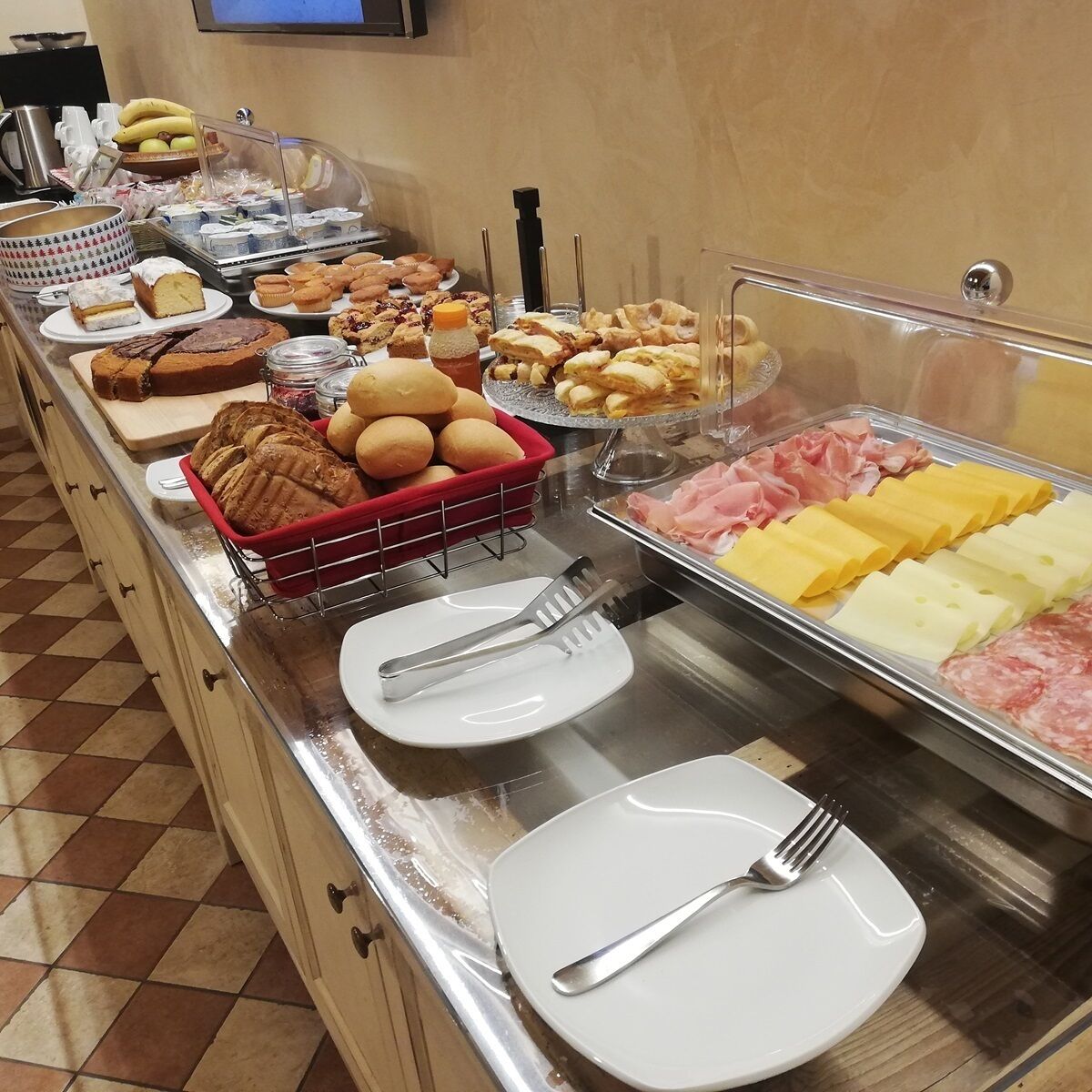 A buffet with various food items, including pastries, meats, and cheeses.