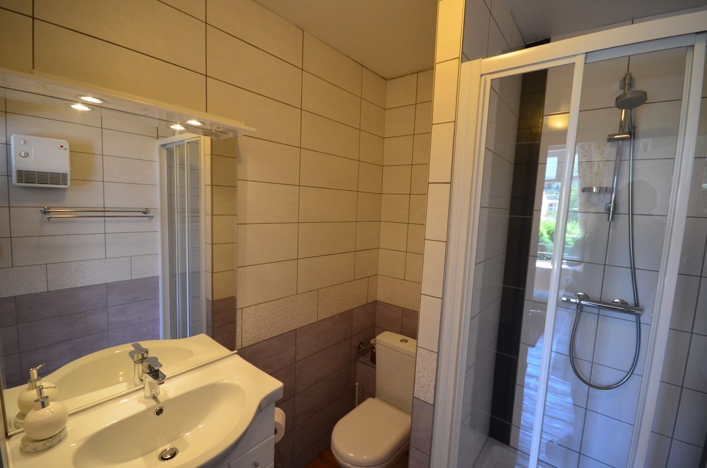 A bathroom with a sink, toilet, and shower.