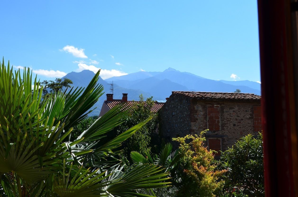 A view of a mountain range with a stone building in the foreground.