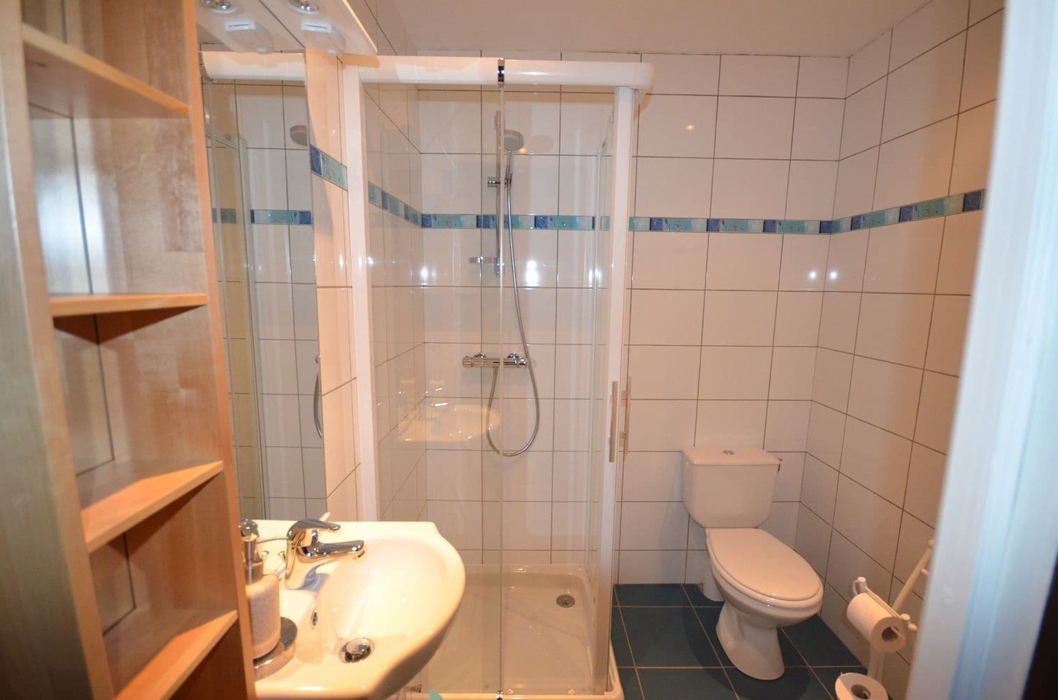 Une salle de bain avec une douche à parois de verre, un lavabo et des toilettes.