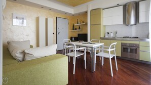 A compact living space with a dining area, kitchenette, and a sofa. - Italianway   - Spadolini 6 (Milan)