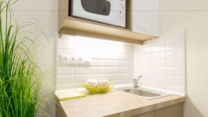 A kitchen with a microwave, sink, and a plant. - Budapest Holiday Colours (Budapest)