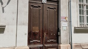 A double wooden door with the number 23, a plaque, and a sign on the wall. - Budapest Holiday Colours (Budapest)